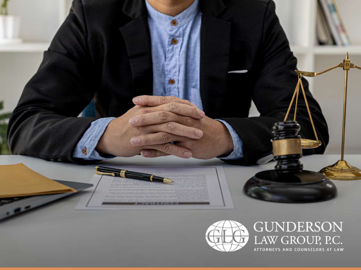 Lawyer seated at a desk with documents, scales of justice, and gavel, discussing the Corporate Transparency Act at Gunderson Law Group